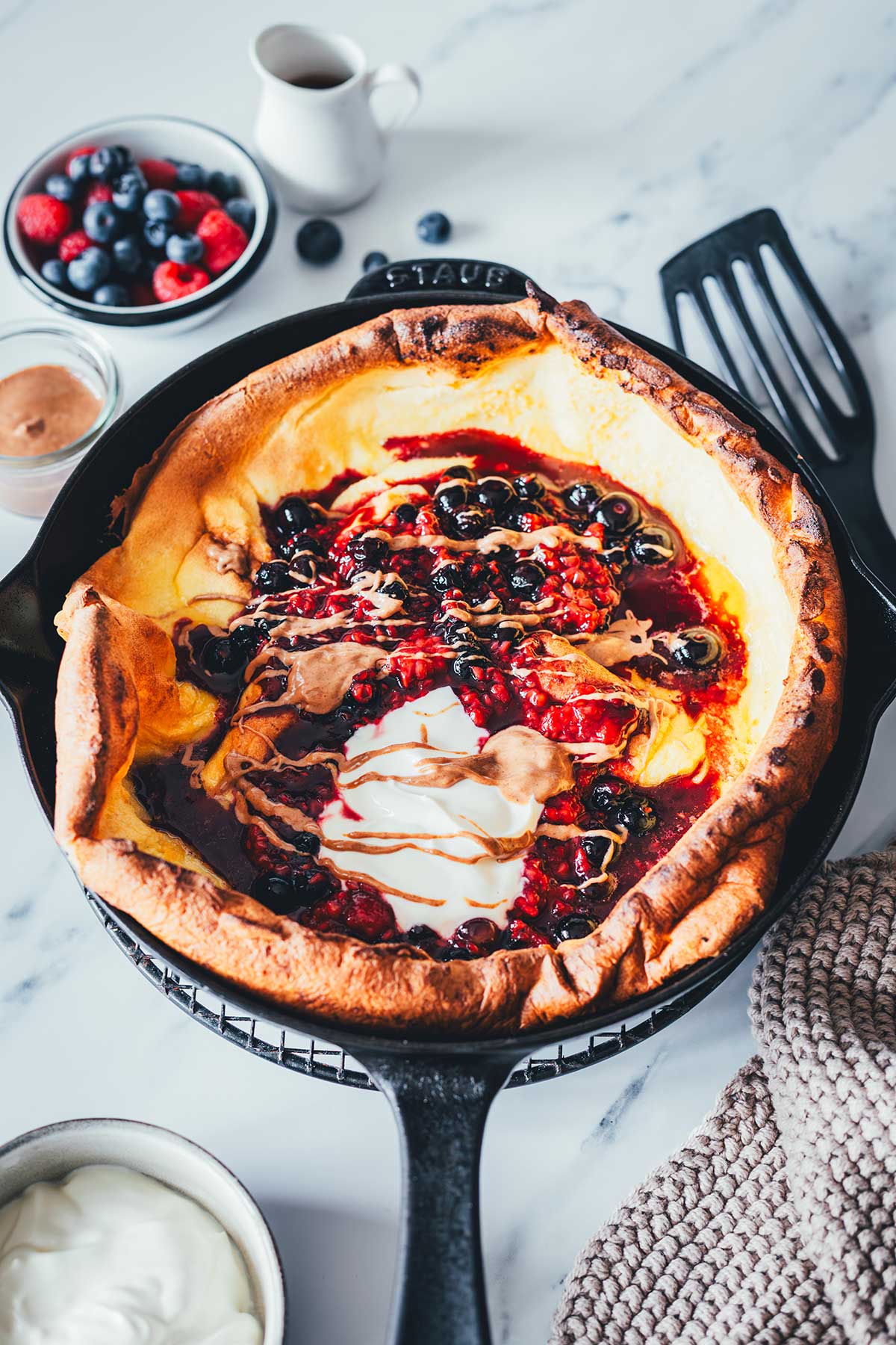 Dutch Baby Rezept für fluffigen Ofenpfannkuchen. Außen knusprig, innen weich, wie ein großer Pancake. Mit Beeren, Ahornsirup und Mandelmus. | moeyskitchen.com