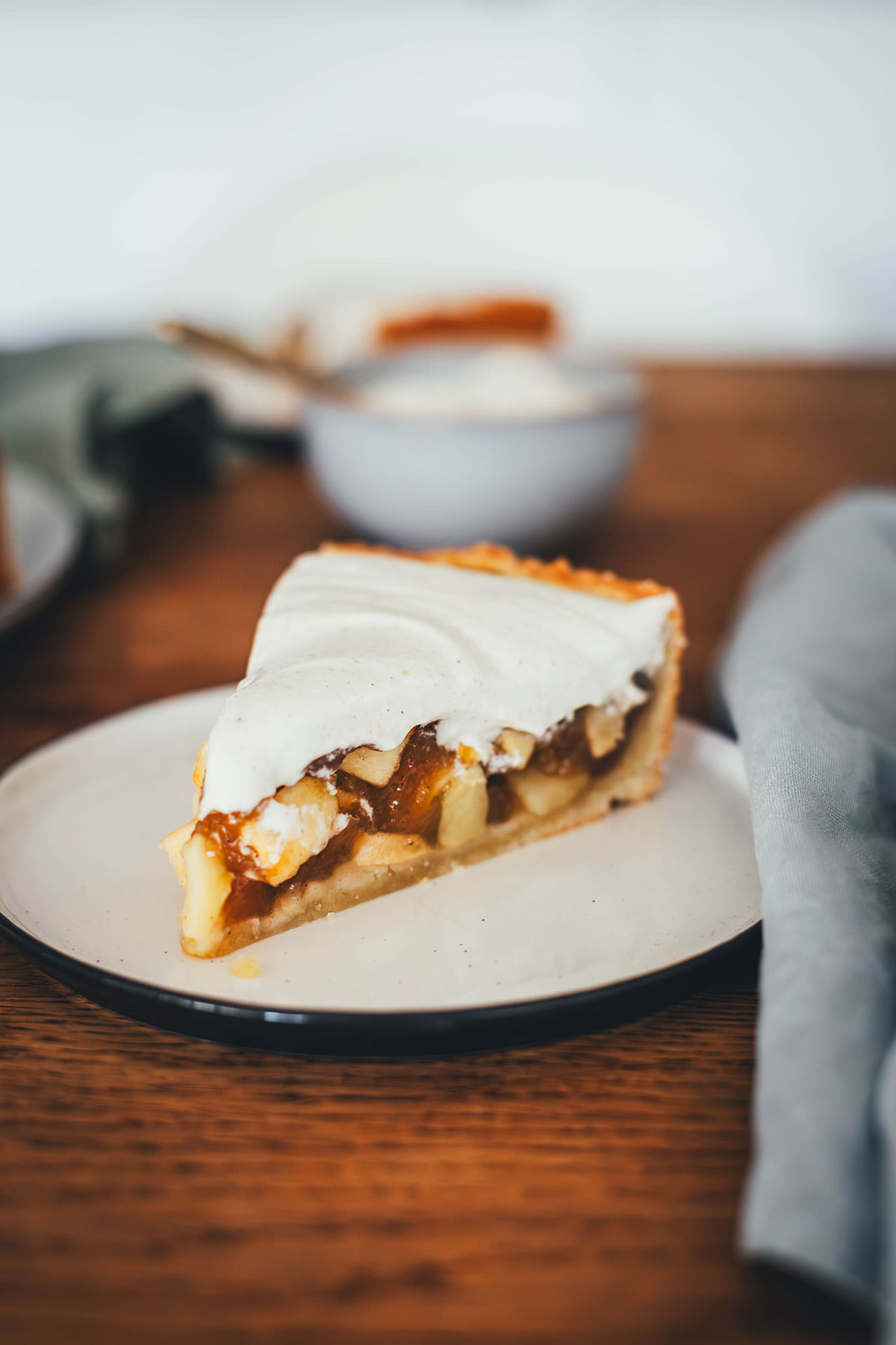 Ein Stück Apfel-Pudding-Kuchen, serviert auf einem Kuchenteller. Angeschnittener Apfelkuchen mit dicker Schmandcreme getoppt. | moeyskitchen.com