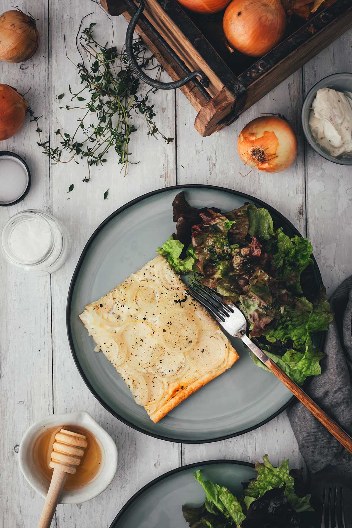 Topshot: Zwiebeltarte mit Zwiebeln und Honig, serviert mit Salat auf grauen Tellern | moeyskitchen.com