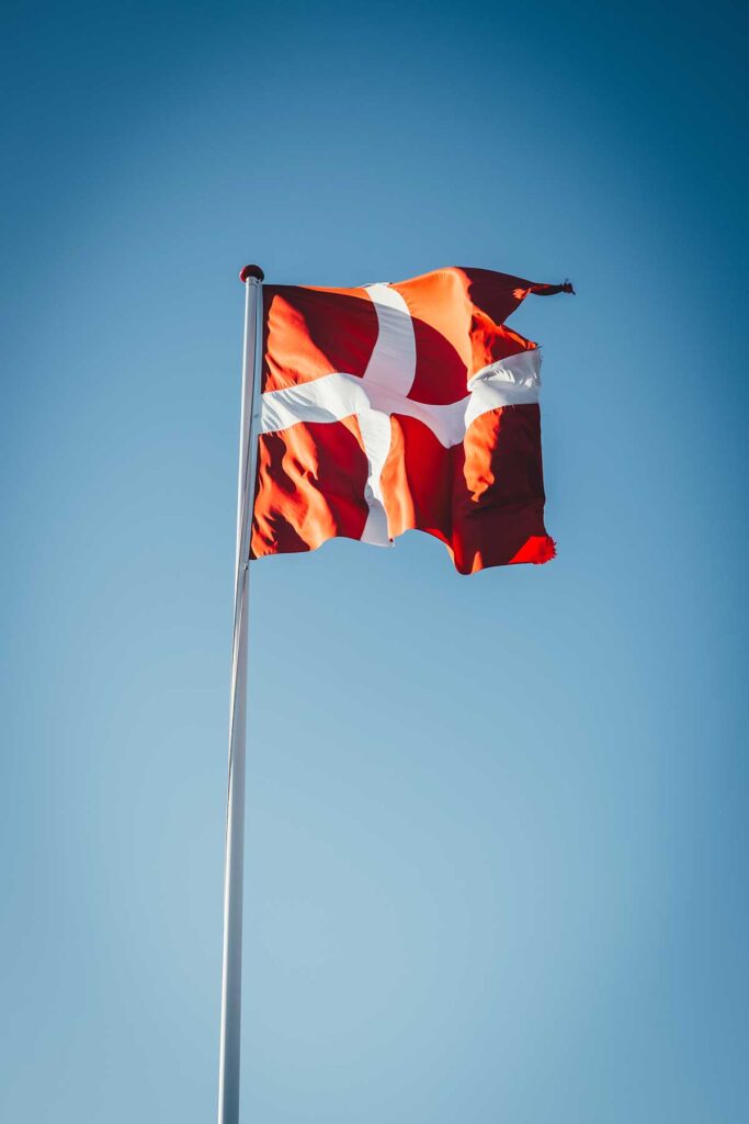 Eine im Wind wehende Dänemark-Flagge vor blauem Himmel | moeyskitchen.com