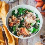 Seitliche Ansicht von einer Salatschüssel mit Herbstsalat – grüner Salat mit Apfel, Ziegenfrischkäse und Walnüssen. Daneben eine gabel mit Holzgriff und eine gelbe Serviette. | moeyskitchen.com