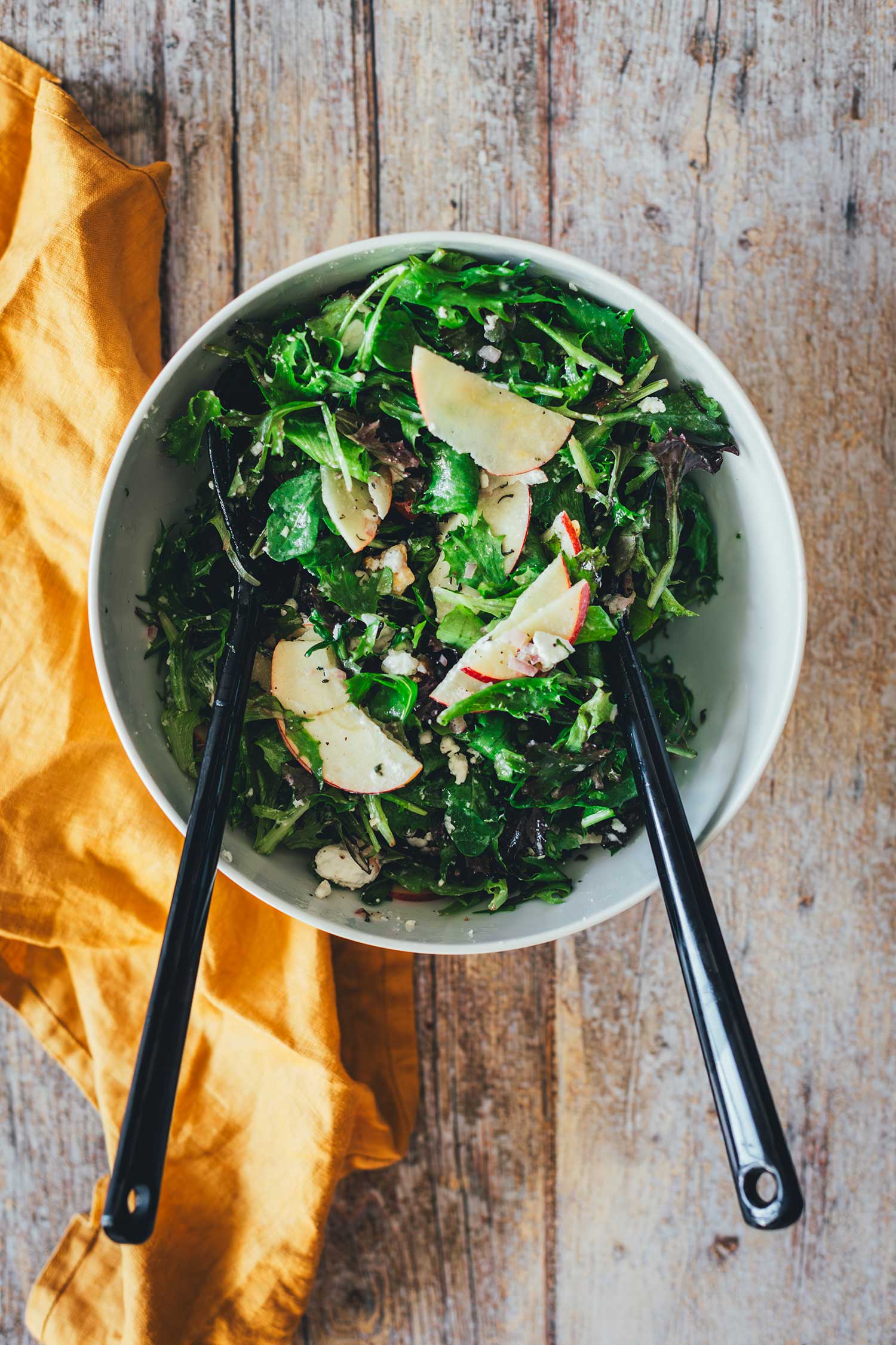 Topshot-Bild in Salatschüssel mit buntem Salat und schwarzem Salatbesteck neben einer goldgelben Serviette | moeyskitchen.com