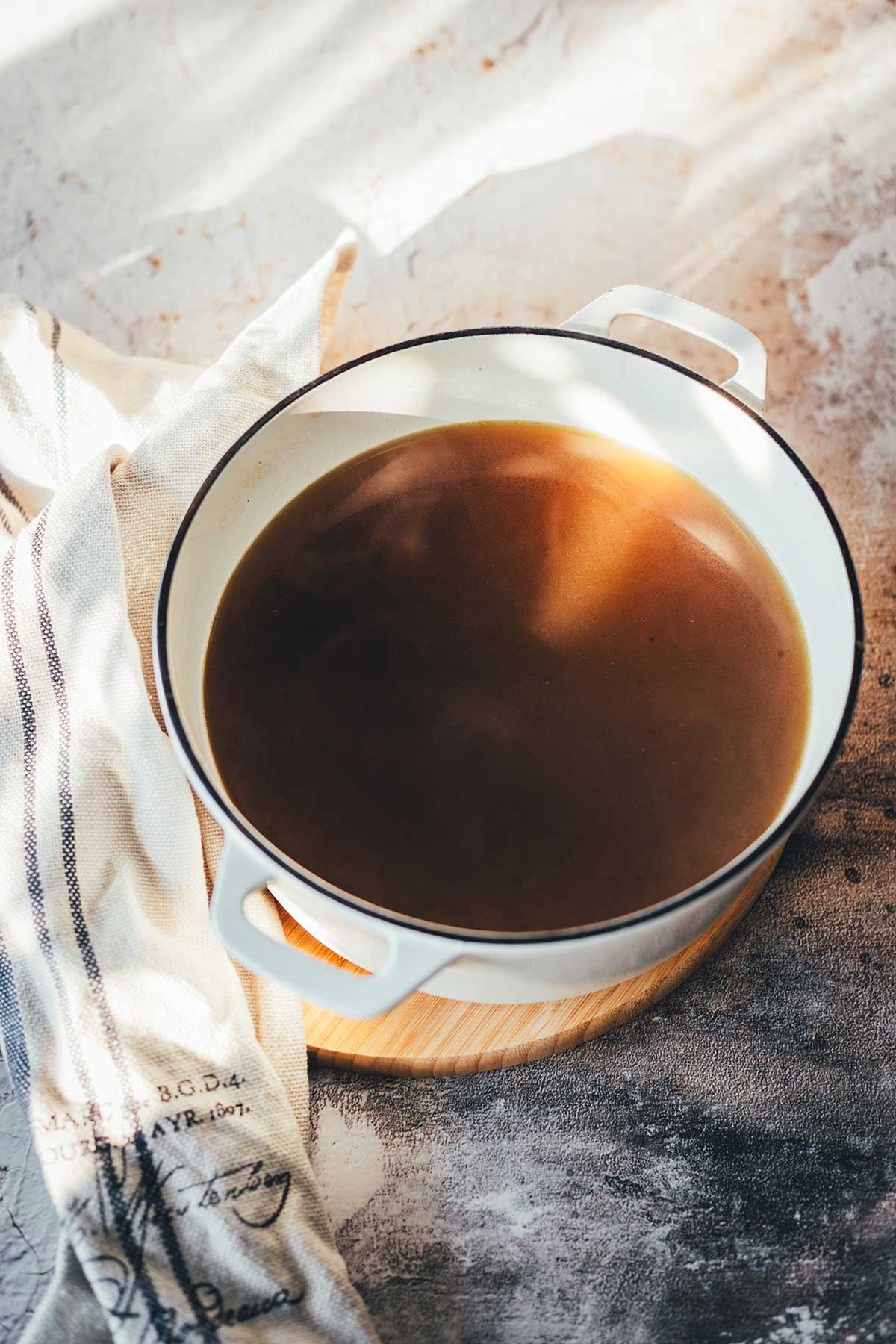 Bild von einem gusseisernen Topf gefüllt mit Gemüsebrühe, dampfend frisch gekocht.