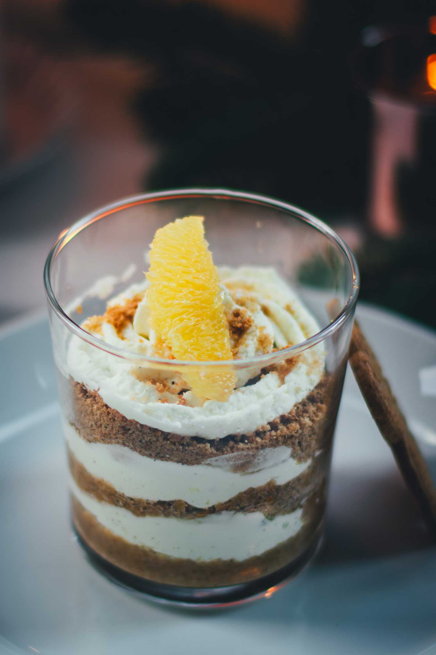 Schichtdessert aus Spekulatius, Mascarponecreme und Orange in einem Glas, getoppt mit einem Orangenfilet.
