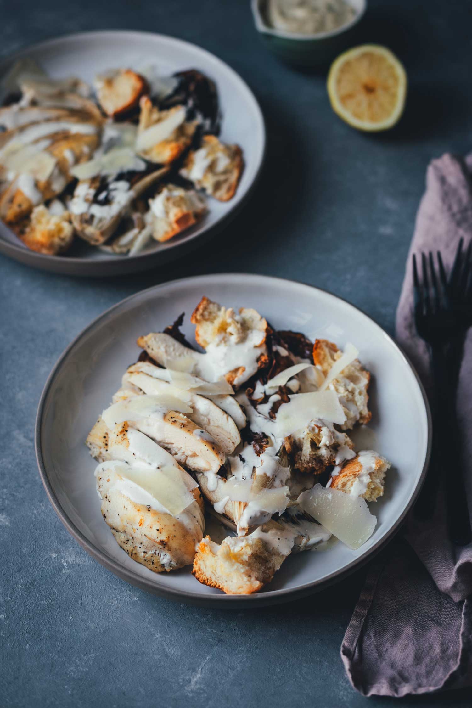 Winterlicher Radicchio Caesar Chicken Salad vom Blech mit geröstetem Radicchio, Hähnchenbrustfilet, Baguette-Croutons und Parmesanspänen.