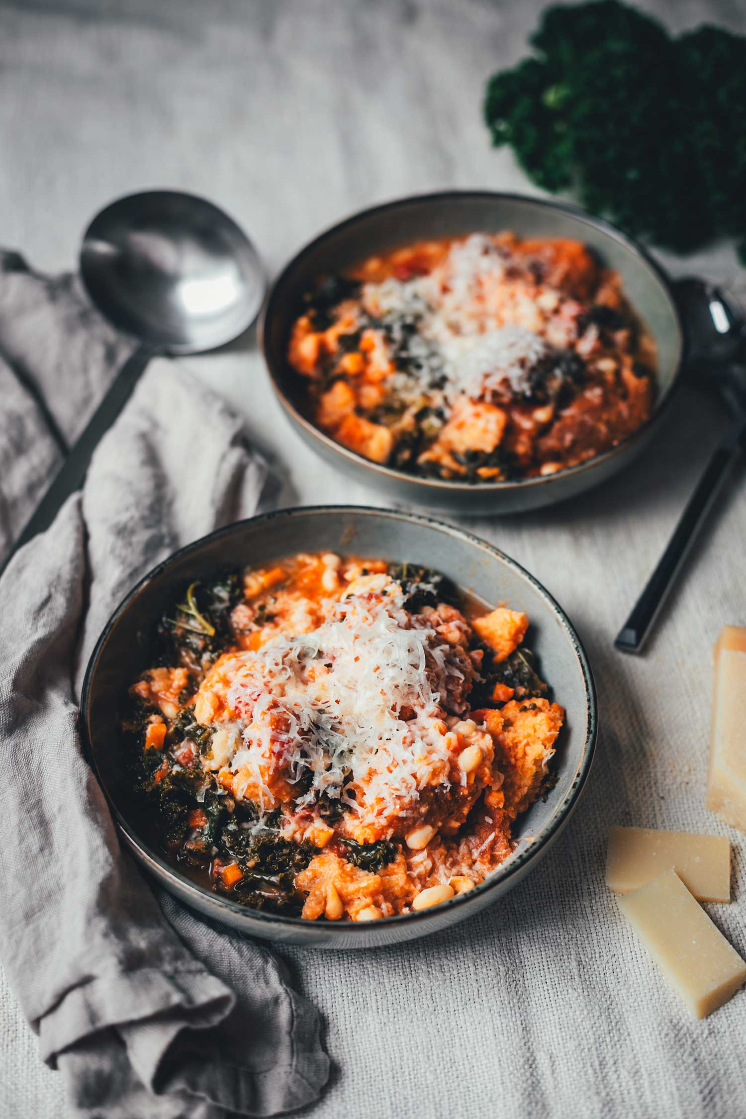Toskanische Ribollita mit Grünkohl, weißen Bohnen, Brot und frisch geriebenem Parmesan in einer Schüssel