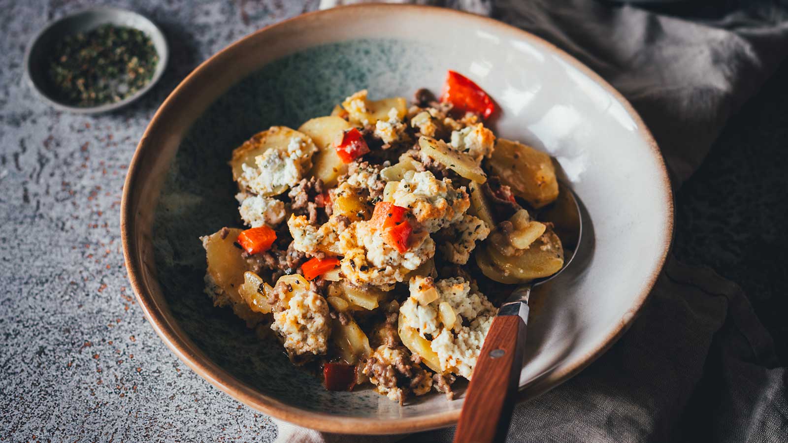 Nahaufnahme einer Portion Kartoffel-Hack-Auflauf auf einem Teller serviert