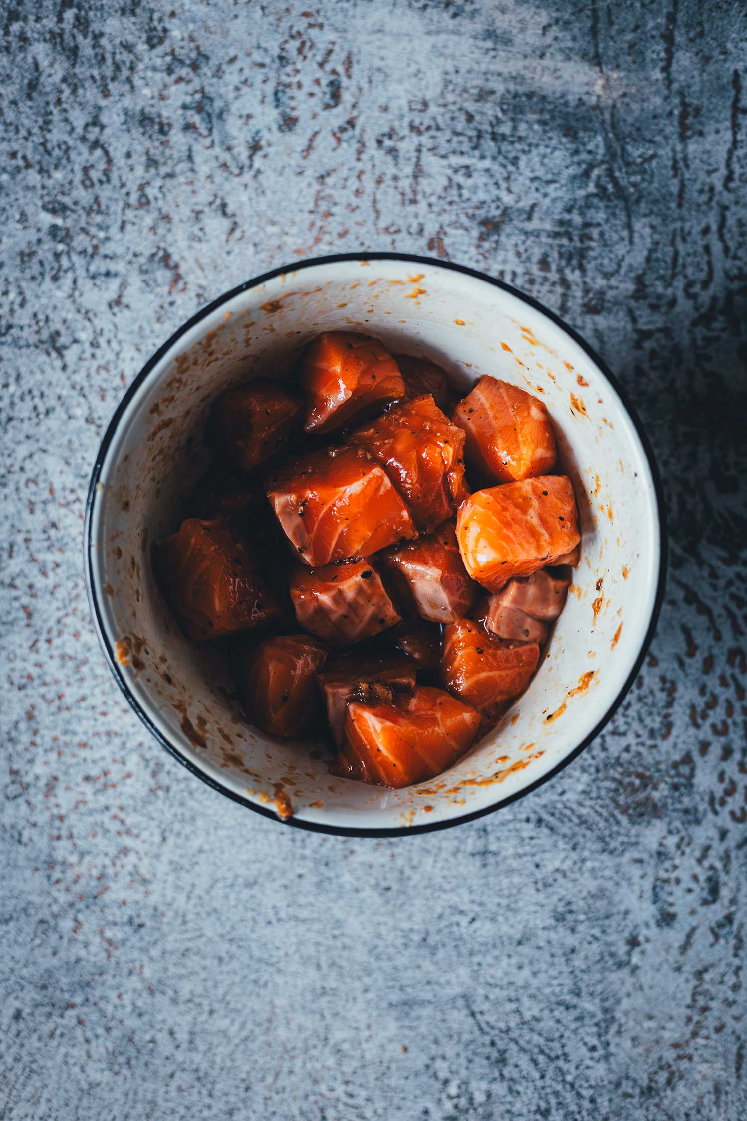 Würfelig geschnittenes Lachsfilet in einer asiatischen Marinade aus Sojasauce und Ingwer als Vorbereitung für die Crispy Lachs Bowl aus dem Airfryer