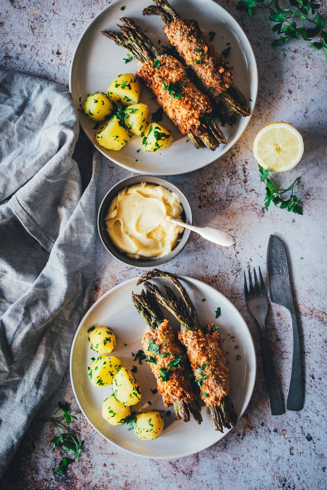 Spargel Cordon Bleu aus dem Airfryer mit grünem Spargel, Salzkartoffeln und Hollandaise auf zwei Tellern von oben