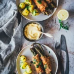 Spargel Cordon Bleu aus dem Airfryer mit grünem Spargel, Salzkartoffeln und Hollandaise auf zwei Tellern von oben