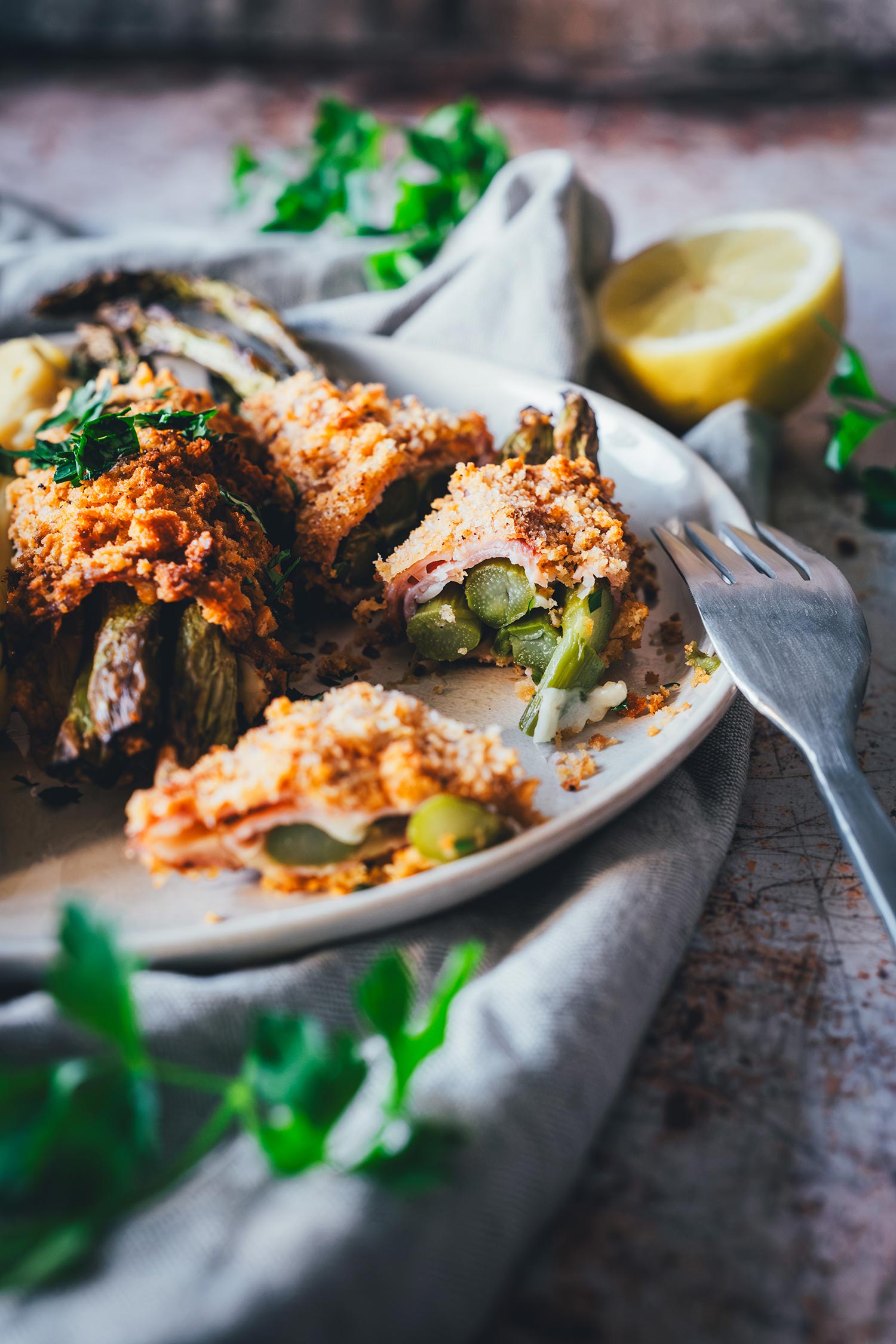 Angeschnittenes Spargel Cordon Bleu mit grünem Spargel und geschmolzenem Gruyère