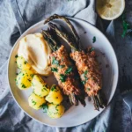 Spargel Cordon Bleu mit Hollandaise und Petersilienkartoffeln auf hellem Teller
