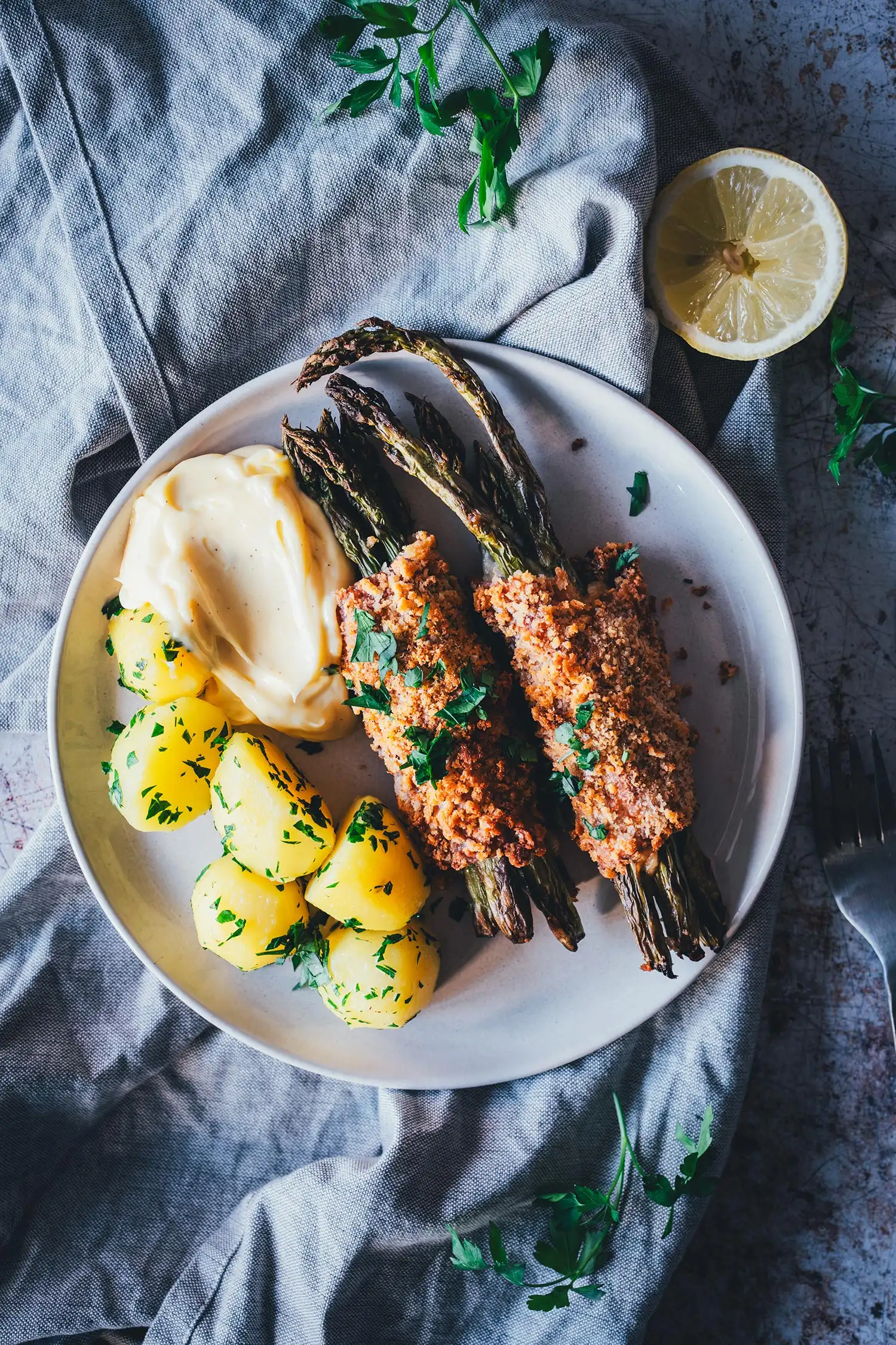 Spargel Cordon Bleu mit Hollandaise und Petersilienkartoffeln auf hellem Teller