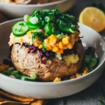 Kumpir-Backkartoffel aus dem Airfryer, getoppt mit Möhren-Joghurt, Mais, Gurkenscheiben und Rotkohlsalat, serviert in einer hellen Schale