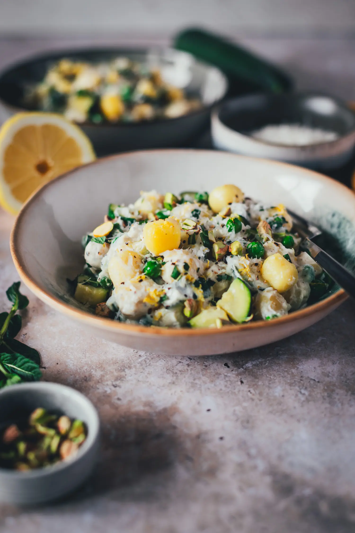 Detailaufnahme einer Lemon Ricotta Gnocchi Bowl mit cremiger Sauce, Erbsen, Zucchini und Pistazien-Crunch