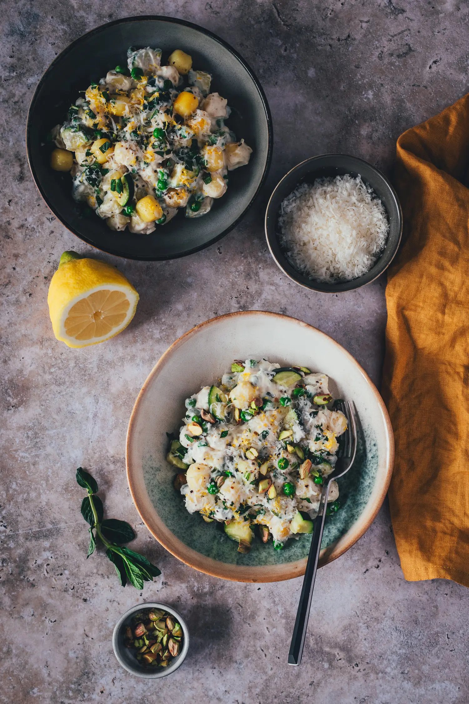 Die fertige Lemon Ricotta Gnocchi Bowl in der Pfanne, cremig verbunden mit Ricotta-Creme, Zucchini und Erbsen