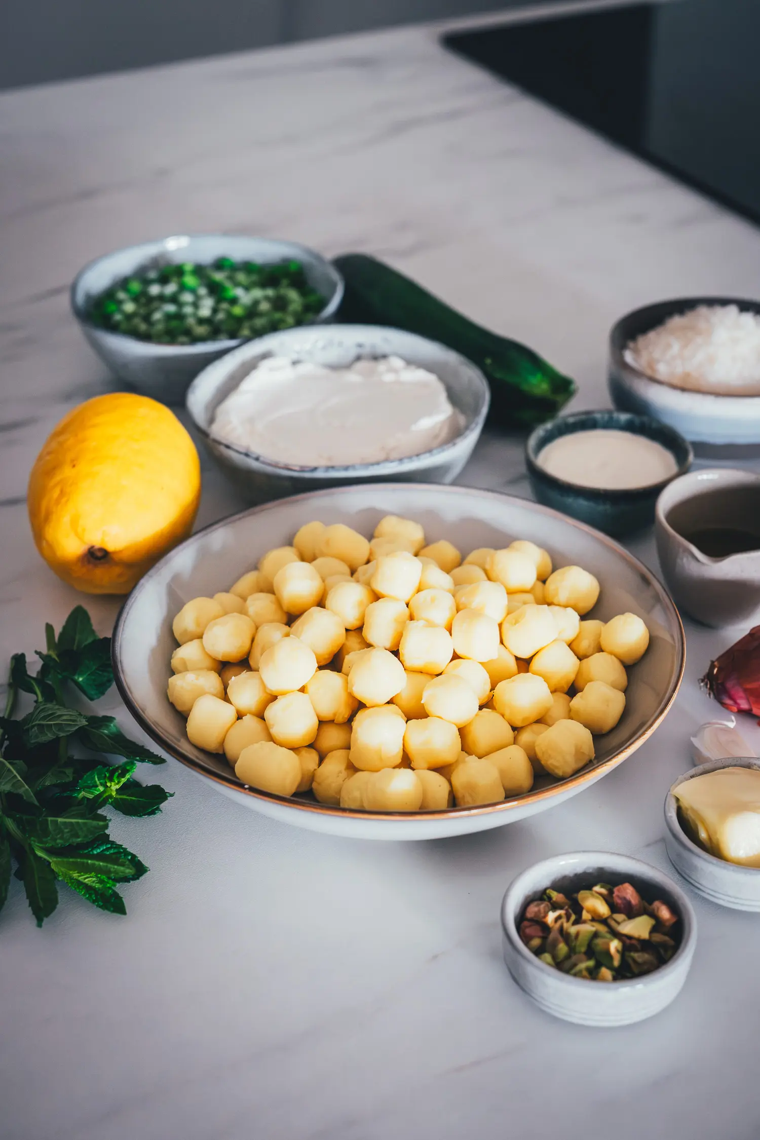 Mise en Place für Lemon Ricotta Gnocchi mit Mini-Gnocchi, Ricotta-Creme, Zucchini, Erbsen, Zitrone und Pistazien