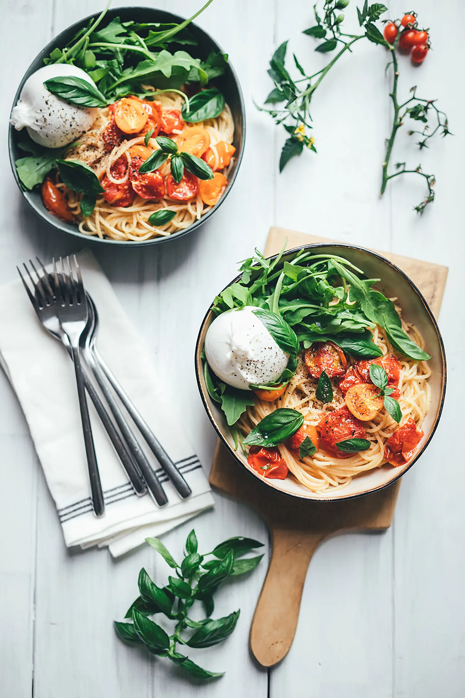 Topshot Aufnahme von zwei Tellern mit sommerlicher Pasta mit Tomaten und Burrata