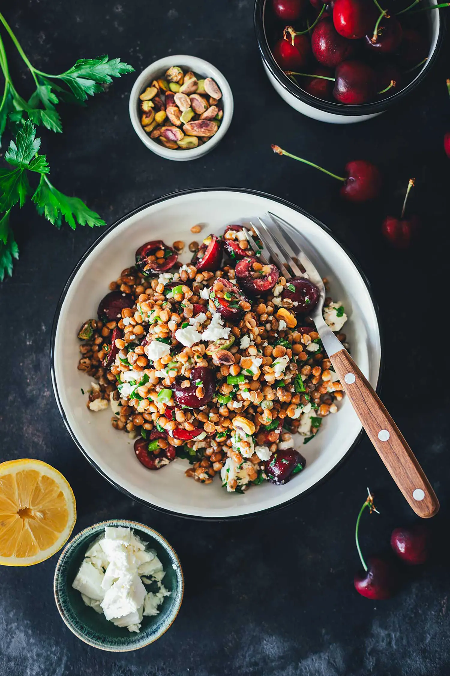 Topshot-Aufnahme von einer großen Schale mit sommerlichem Linsensalat mit Kirschen.
