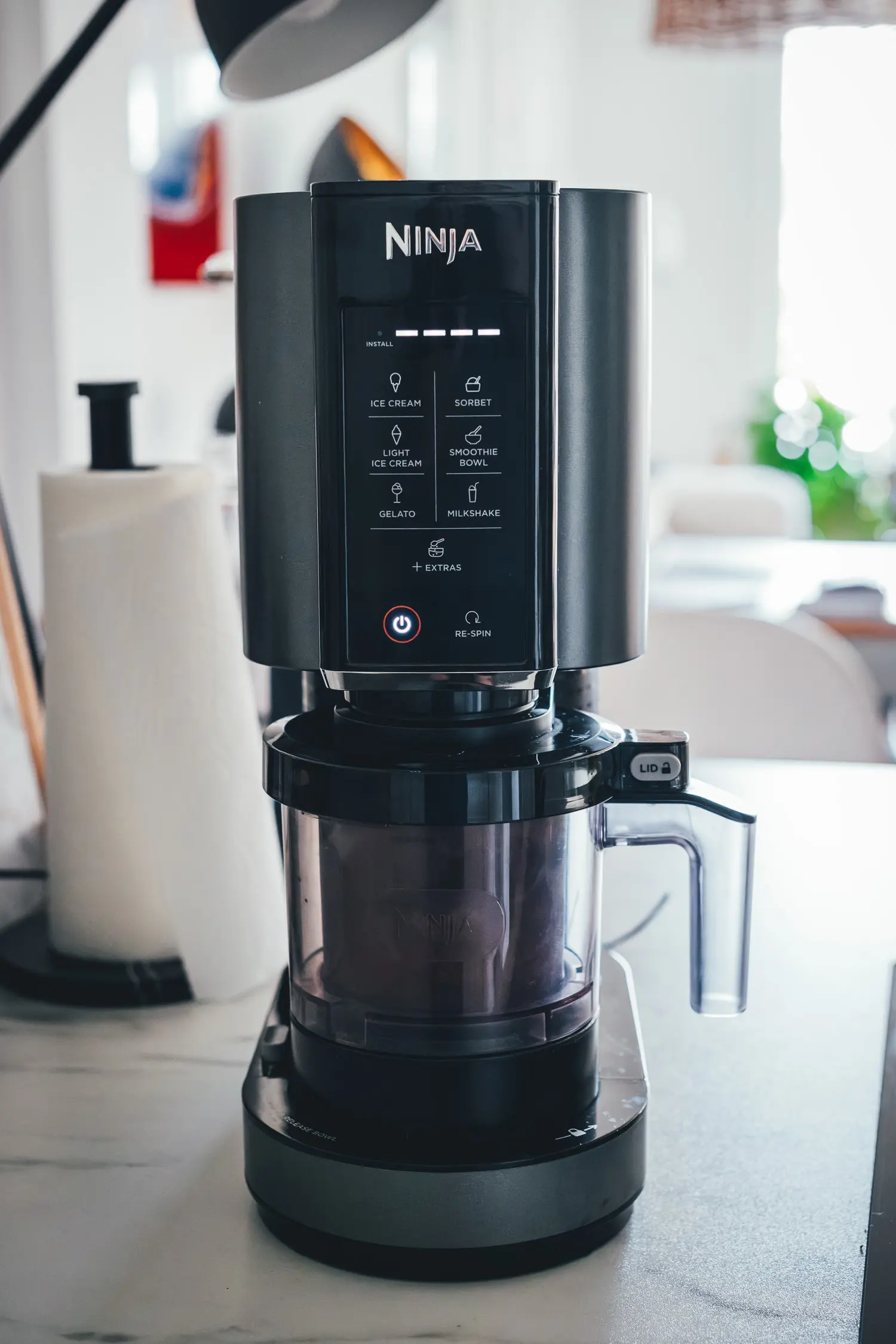 Frontale Ansicht eines Ninja Creami im Betrieb, in einer Küche stehend.