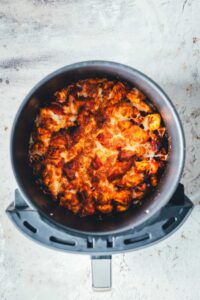 Fertig überbackener Gnocchi-Auflauf mit geschmolzenem Mozzarella und Tomatensauce im Korb der Heißluftfritteuse